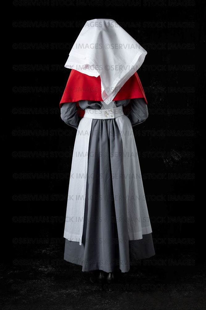 World War 1 nurse in grey uniform dress with a white apron and red