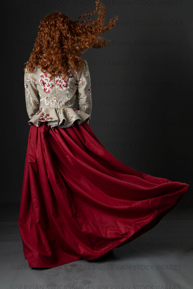 Renaissance or fantasy woman in an embroidered bodice and red skirt back view  (Quinn 867)