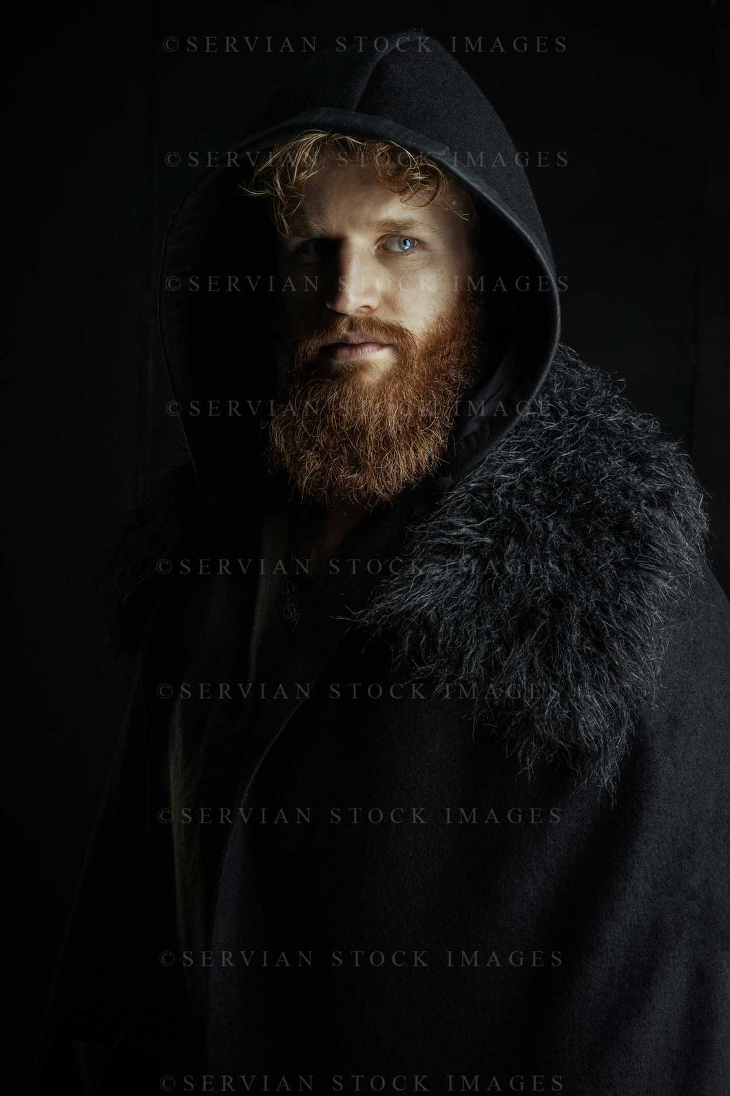 Viking or high fantasy man with red hair and beard wearing a black cape with fur against a black backdrop with colour grading(Luke 3168-2)