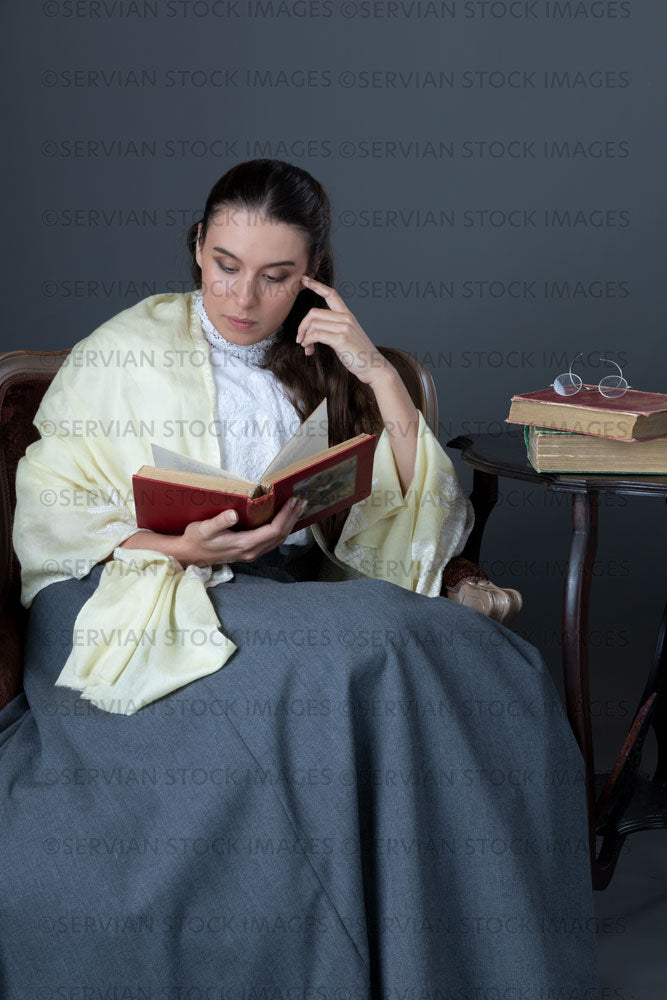 Victorian or Edwardian woman with long hair sitting in a chair reading a book  (Sarah 1703)
