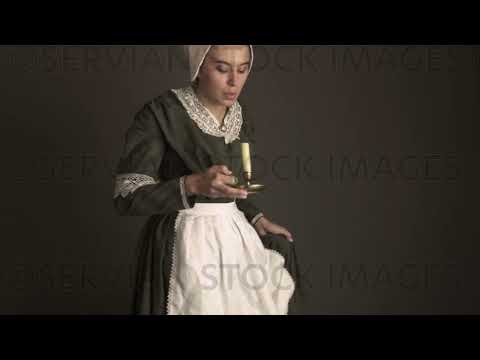 Victorian maid servant wearing a dark green check bodice and skirt carries a candle   (Sarah 1729)