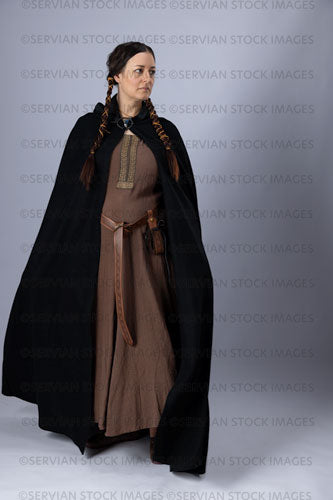 Medieval woman wearing a brown linen kirtle and a black woolen cloak (Emma 1094)