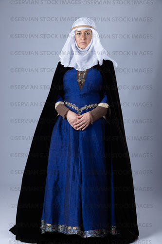 Medieval woman wearing a blue silk bliaut gown with a white wimple and velvet cloak (Emma 1202)