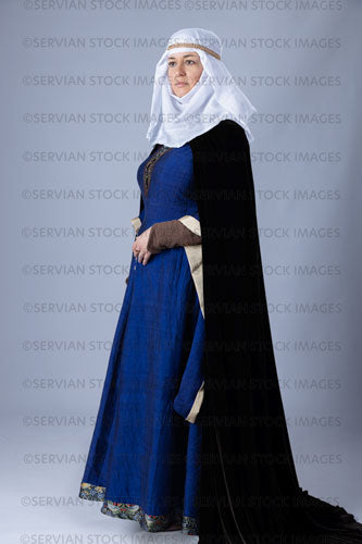 Medieval woman wearing a blue silk bliaut gown with a white wimple and velvet cloak (Emma 1211)