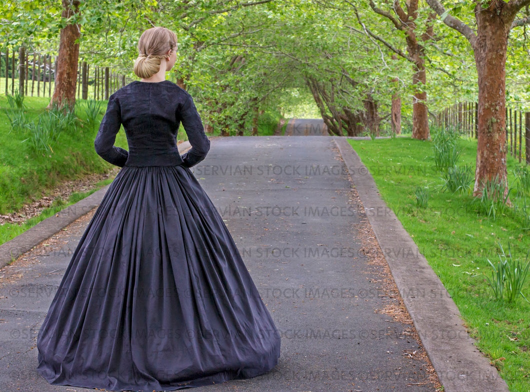 Victorian woman in a black ensemble outdoors under a grove of trees   (Ashley 0059)