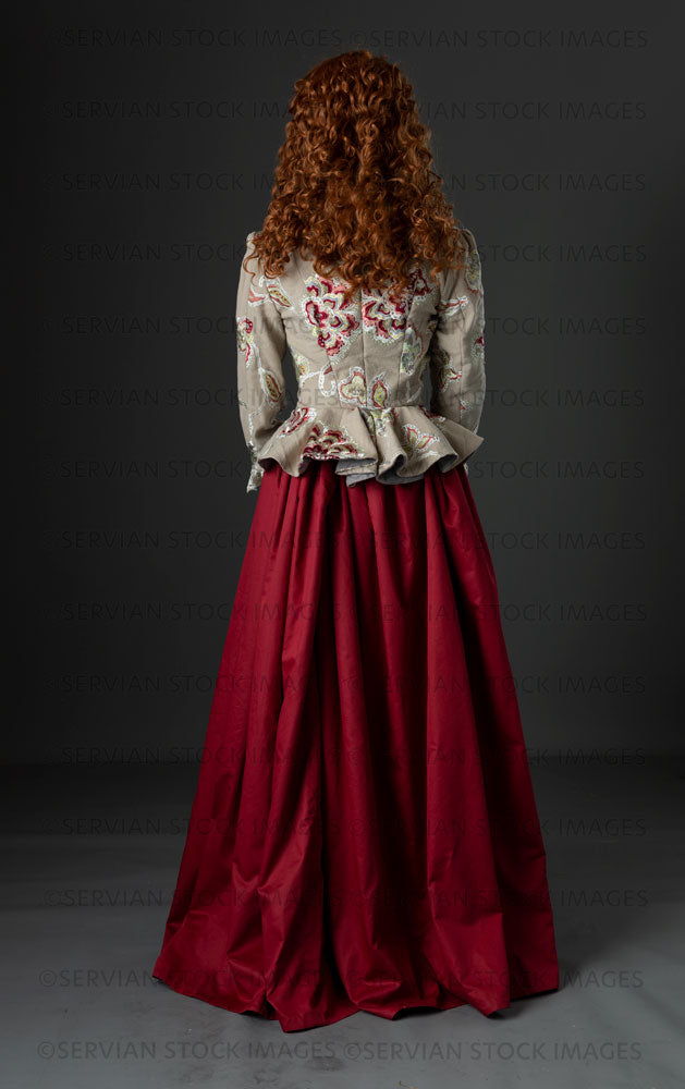Renaissance or fantasy woman in an embroidered bodice and red skirt back view  (Quinn 862)