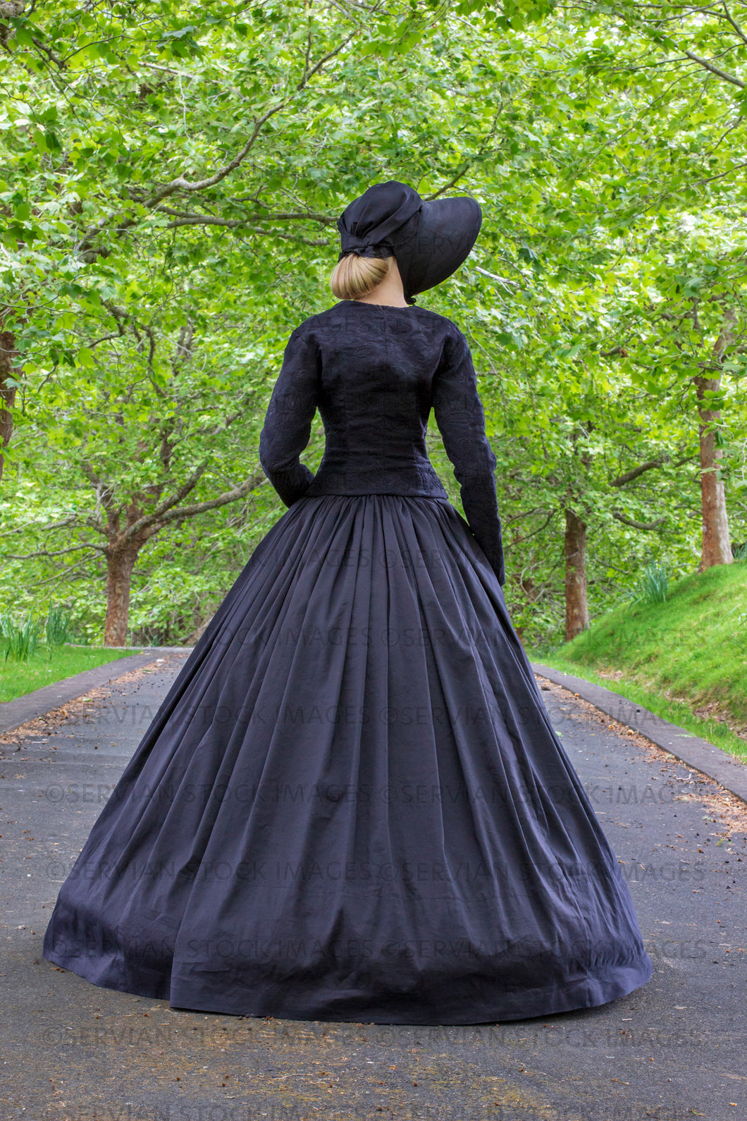 Victorian woman in a black ensemble outdoors under a grove of trees   (Ashley 0190)