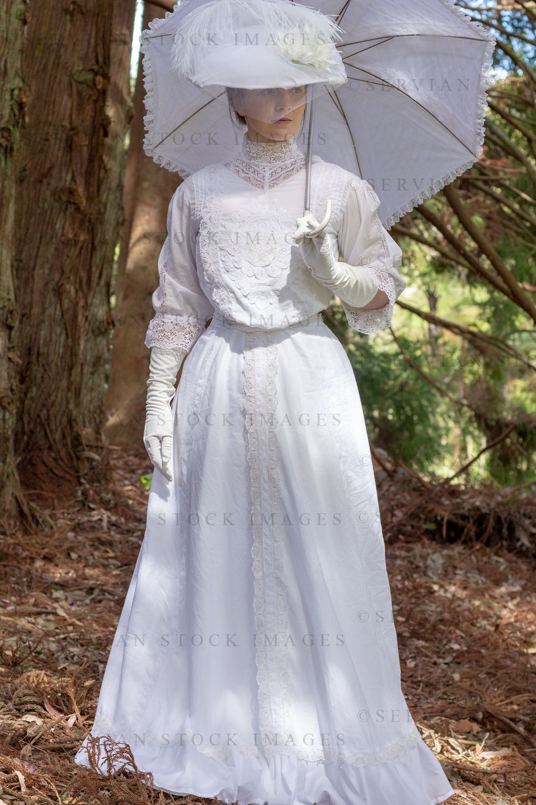 Edwardian woman in a white lace blouse and skirt and walking in a garden (Tayla 0261)