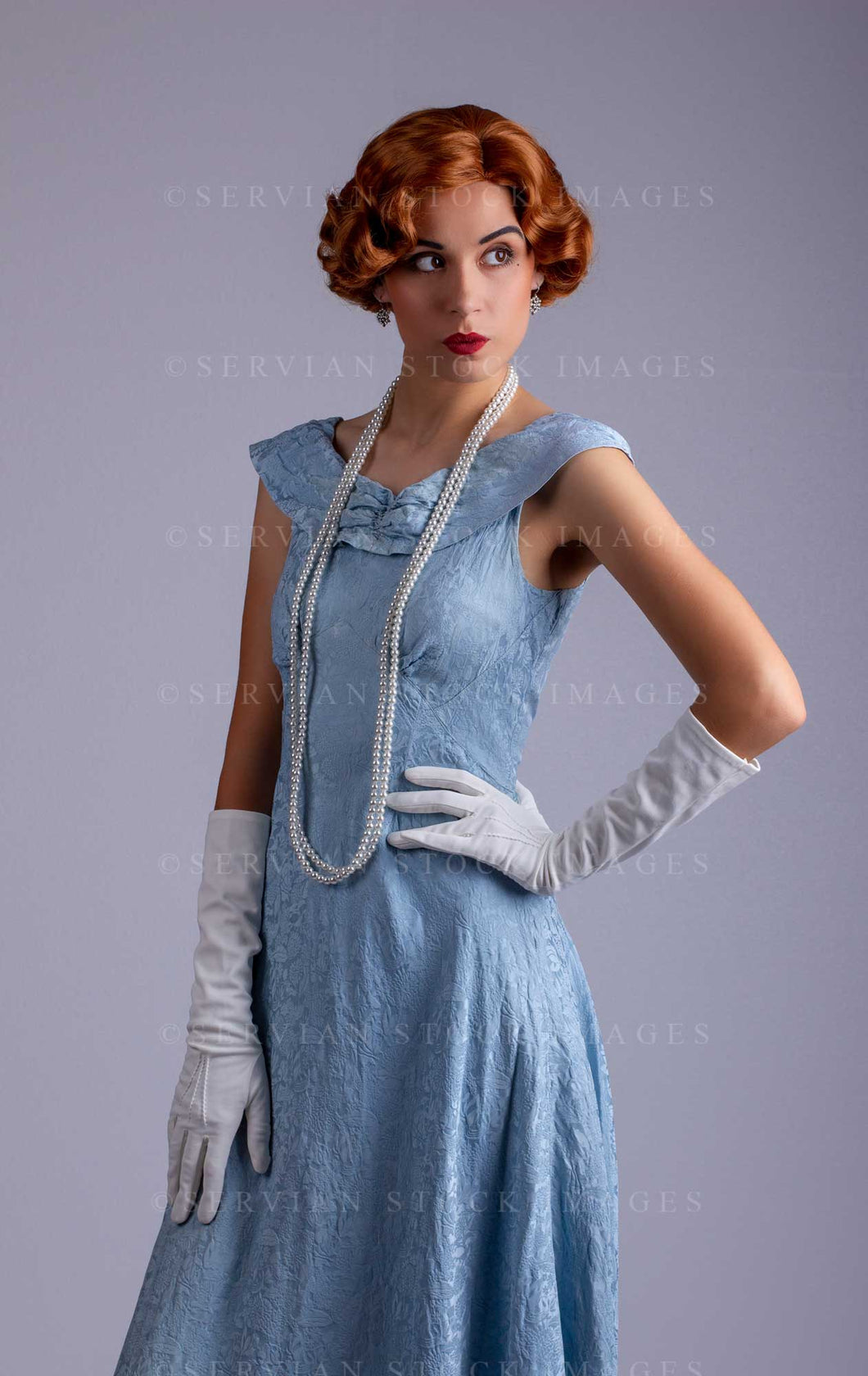 1930s woman wearing a blue vintage dress and a long string of pearls (Sarah 0077)