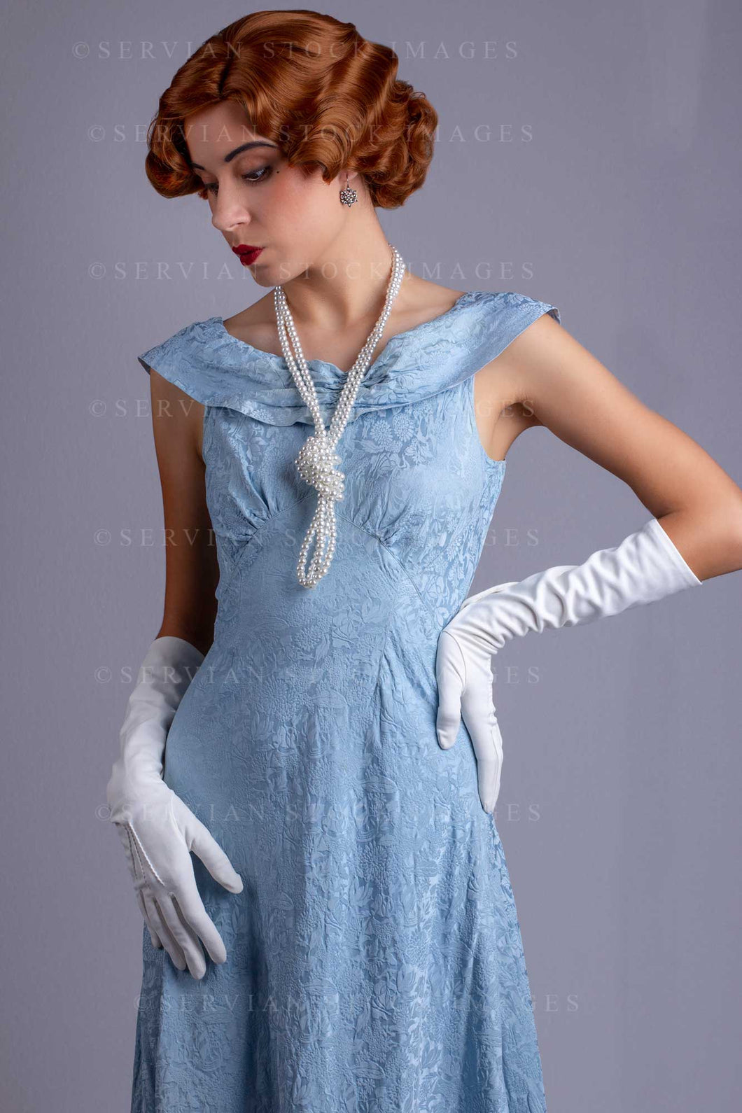 30s cocktail dress 1930s woman wearing a blue vintage dress and a long string of pearls ( – Servian Stock Images