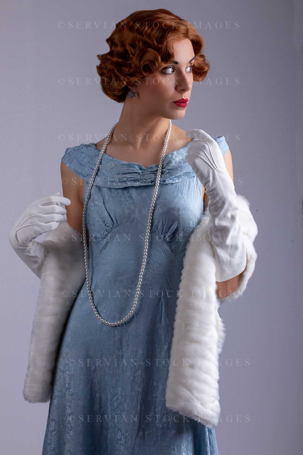 1930s woman wearing a blue vintage dress and a long string of pearls a – Servian Stock Images 1930s woman wearing a blue vintage dress and a long string of pearls a – Servian Stock Images