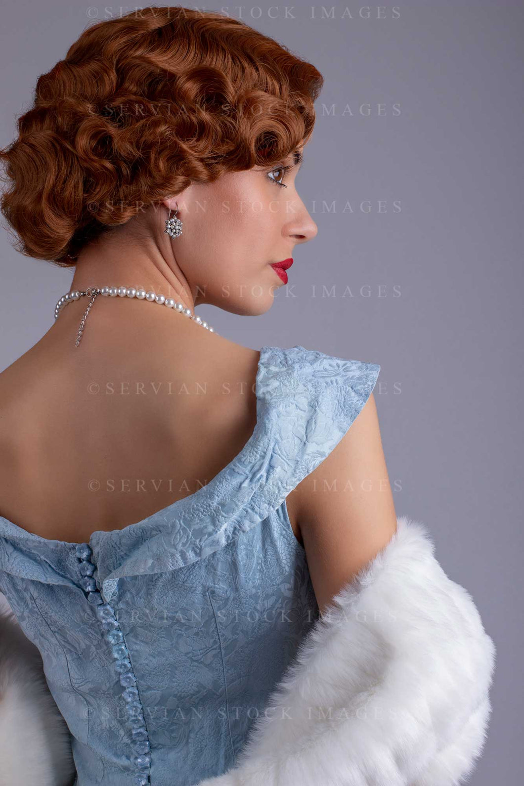 1930s woman wearing a blue vintage dress and a long string of pearls a Servian Stock Images 1930s woman wearing a blue vintage dress and a long string of pearls a Servian Stock Images