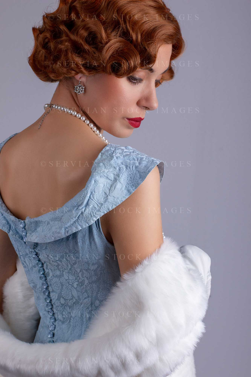 1930s woman wearing a blue vintage dress and a long string of pearls and white fur wrap (Sarah 0167)