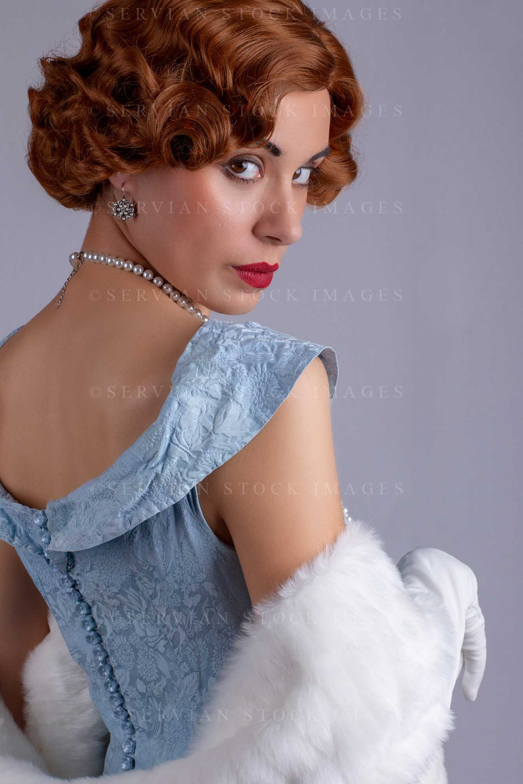 1930s woman wearing a blue vintage dress and a long string of pearls and white fur wrap (Sarah 0169)