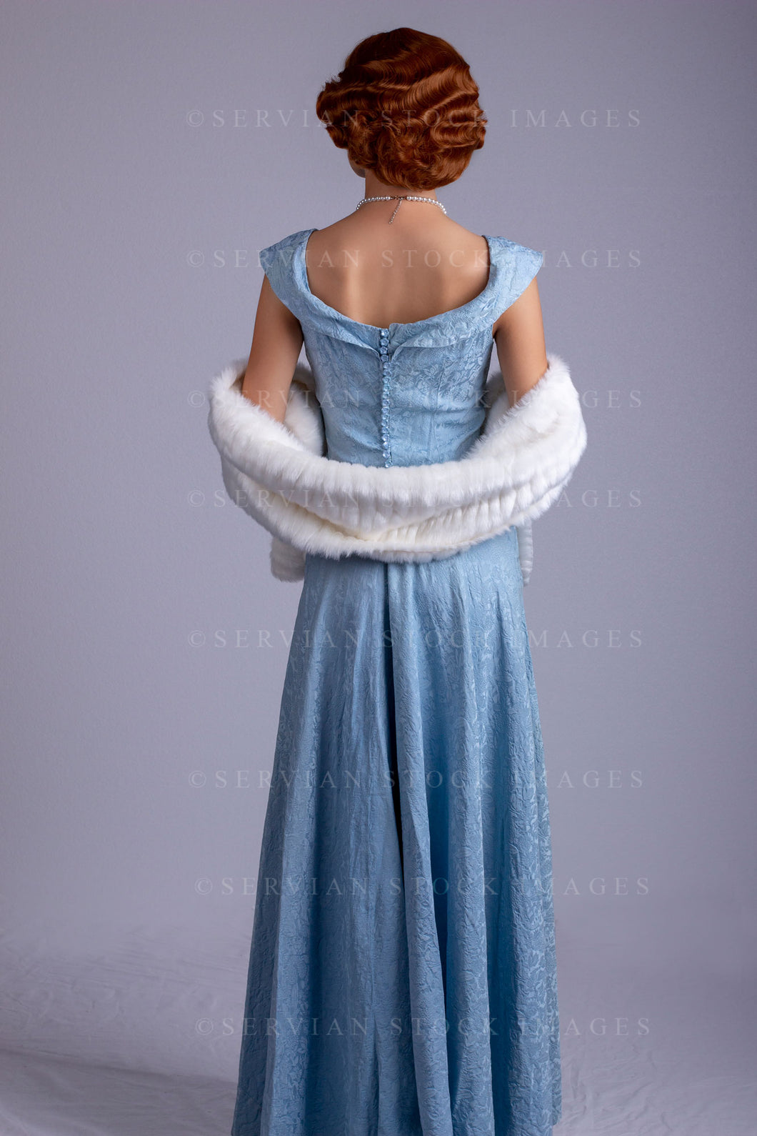 1930s woman wearing a blue vintage dress and a long string of pearls and white fur wrap (Sarah 0172)