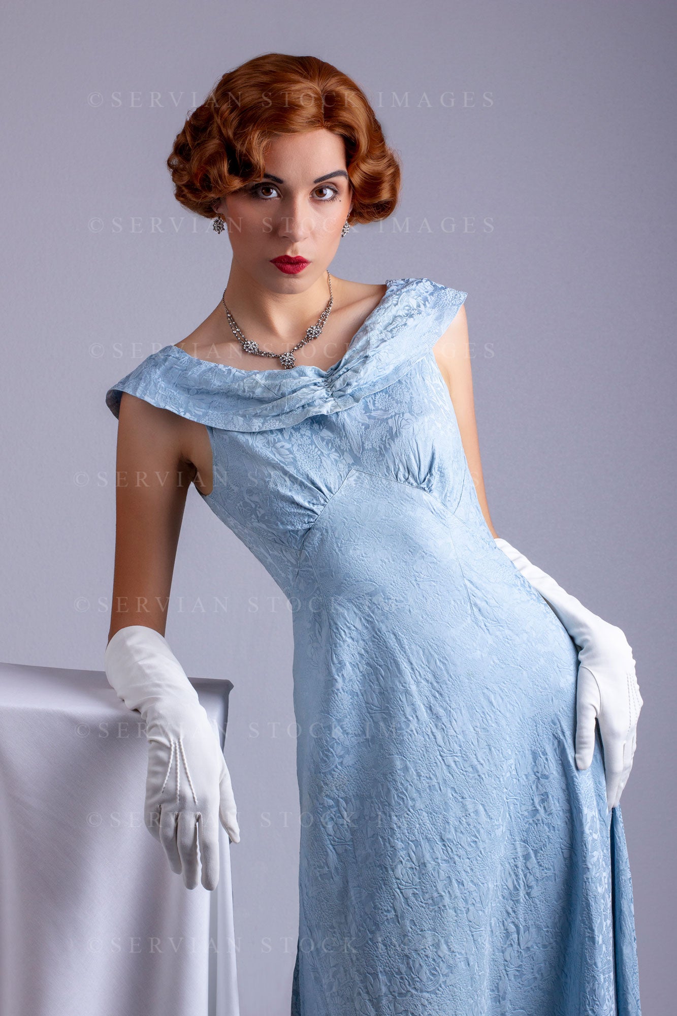 1930s woman wearing a blue vintage dress and diamante necklace (Sarah – Servian Stock Images
