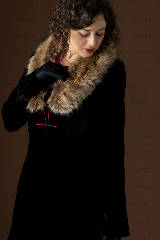 1920s woman wearing a black velvet coat with a dark red day dress (Emma 252)