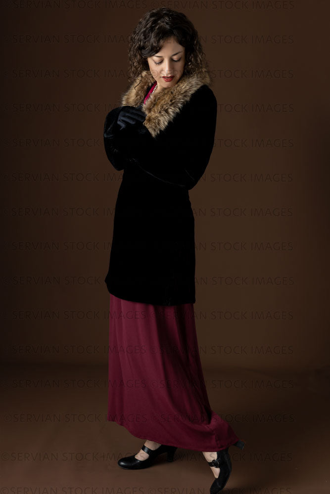 1920s woman wearing a black velvet coat with a dark red day dress (Emma 254)