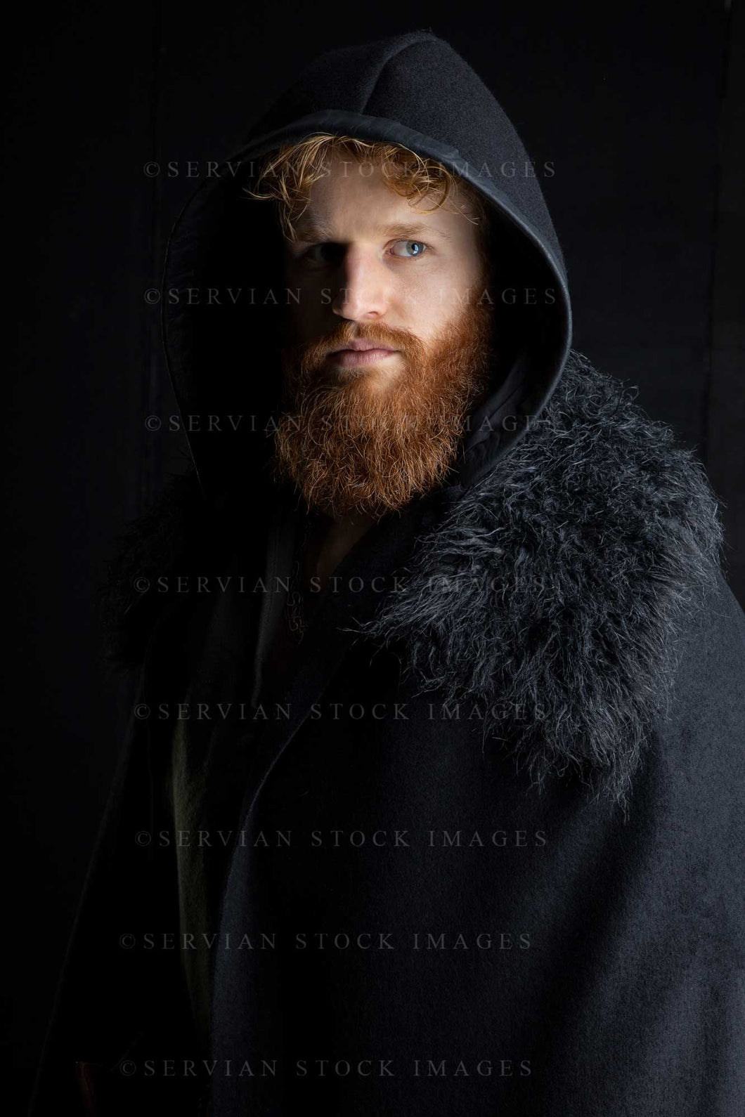 Viking or high fantasy man with red hair and beard wearing a black cape with fur against a black backdrop (Luke 3168)