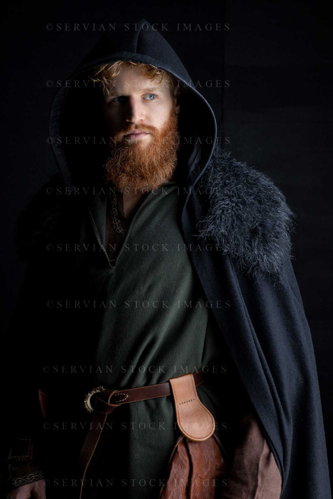 Viking or high fantasy man with red hair and beard wearing a black cape with fur against a black backdrop with colour grading(Luke 3171)