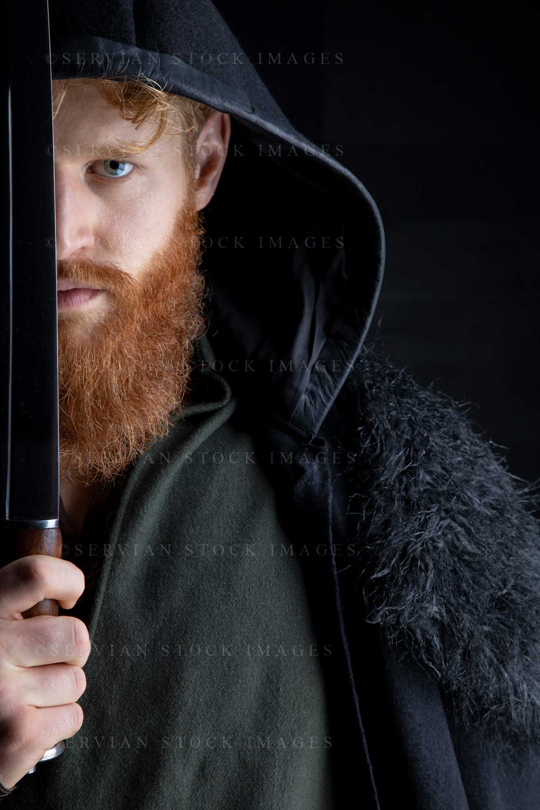 Viking or high fantasy man with red hair and beard wearing a black cloak and carrying a sword against a black backdrop (Luke 3192)