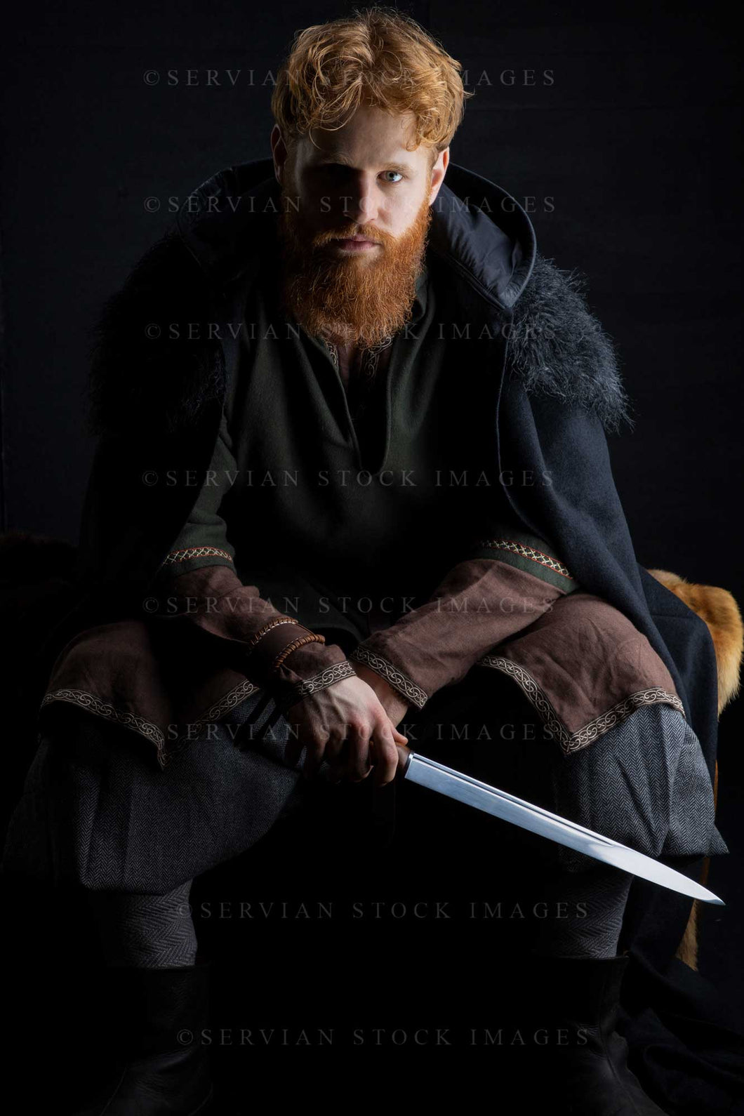 Viking or high fantasy man with red hair and beard wearing a black cloak against a black backdrop (Luke 3206)