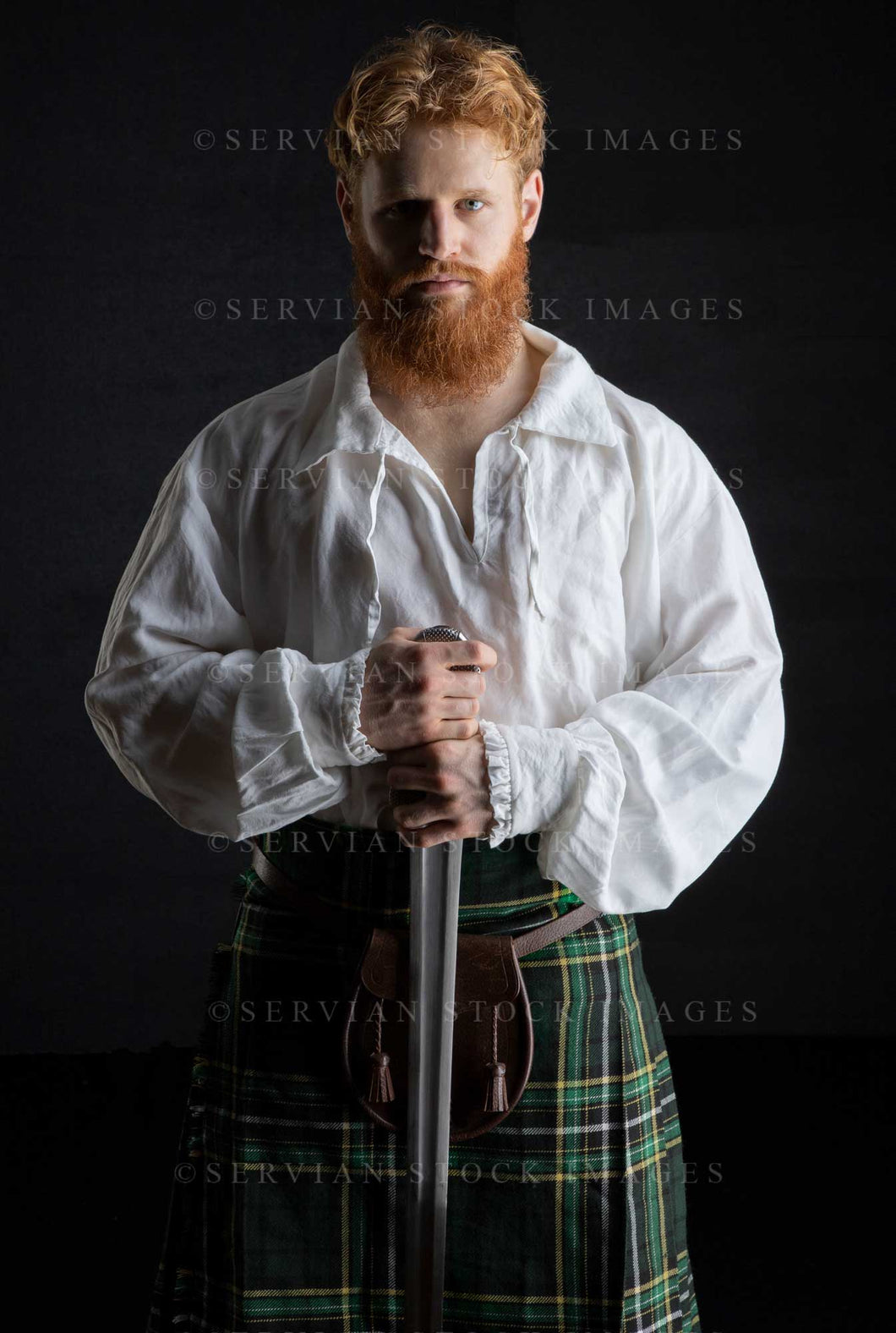 Scotsman with red hair and beard wearing a kilt and linen shirt against a black backdrop (Luke 3235)
