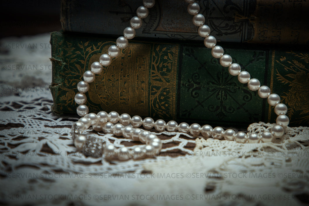 Still life - Vintage pearls draped over old books (KS 9561)