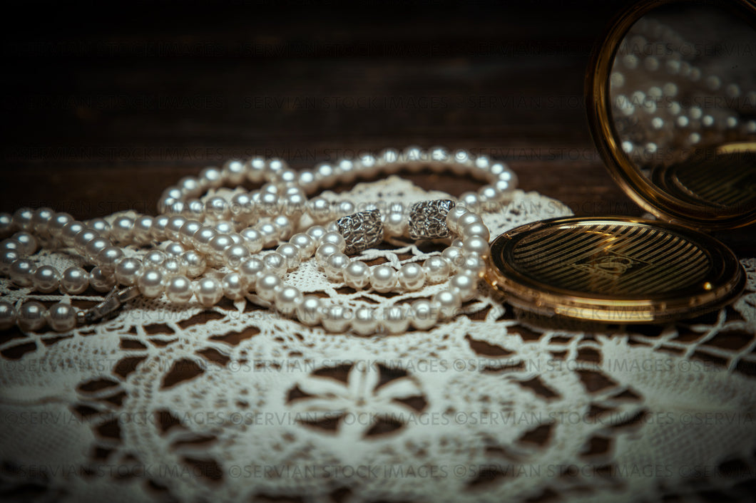 Still life -   Vintage pearls, fan, and compact in a handmade doily (KS 9624)