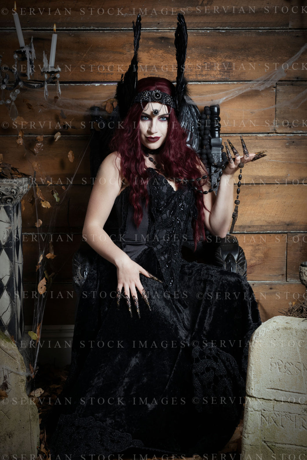 High Fantasy witch sitting on a black, gothic throne wearing a feathered headdress (Victoria 2595)
