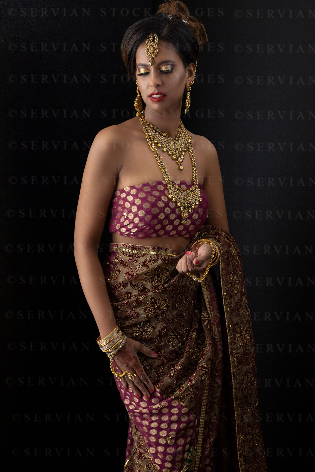 Woman wearing a sari and gold jewellery against a black backdrop (Shelaila 4338)