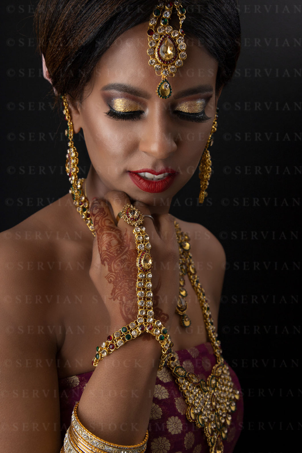 Woman wearing a sari and gold jewellery against a black backdrop (Shelaila 4358)