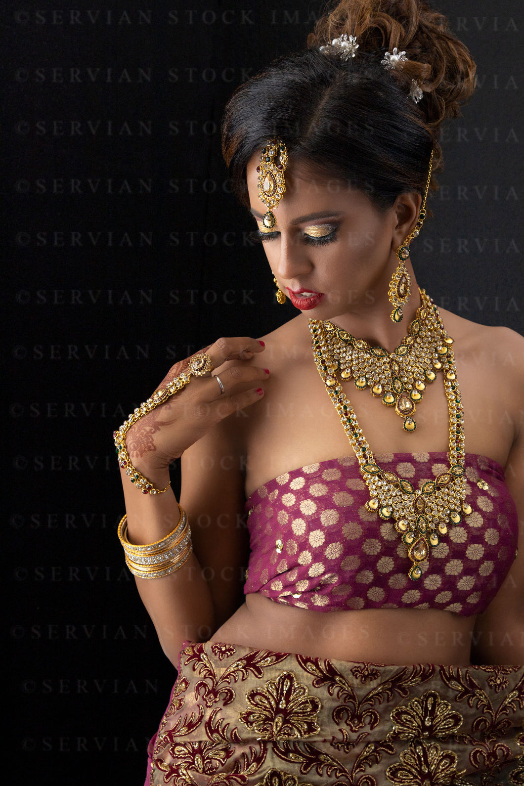 Woman wearing a sari and gold jewellery against a black backdrop (Shelaila 4366)