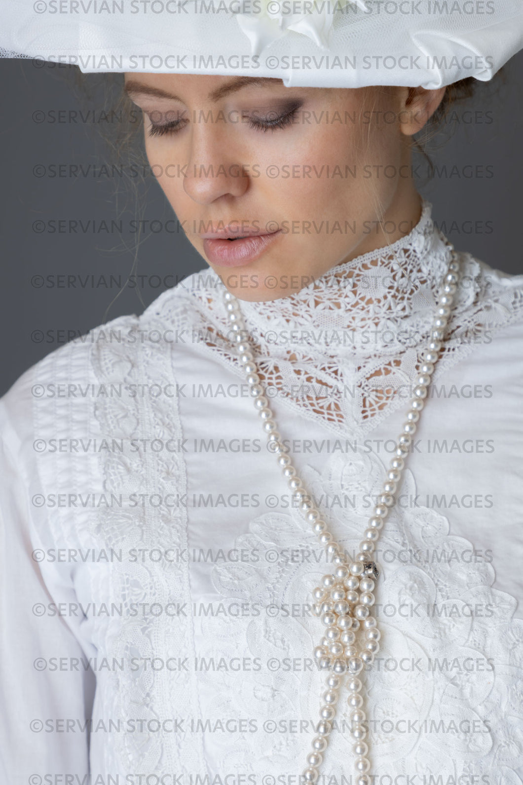 Edwardian woman in a white lace blouse and skirt with a pearl necklace and a large hat (Anastasiya 4973)