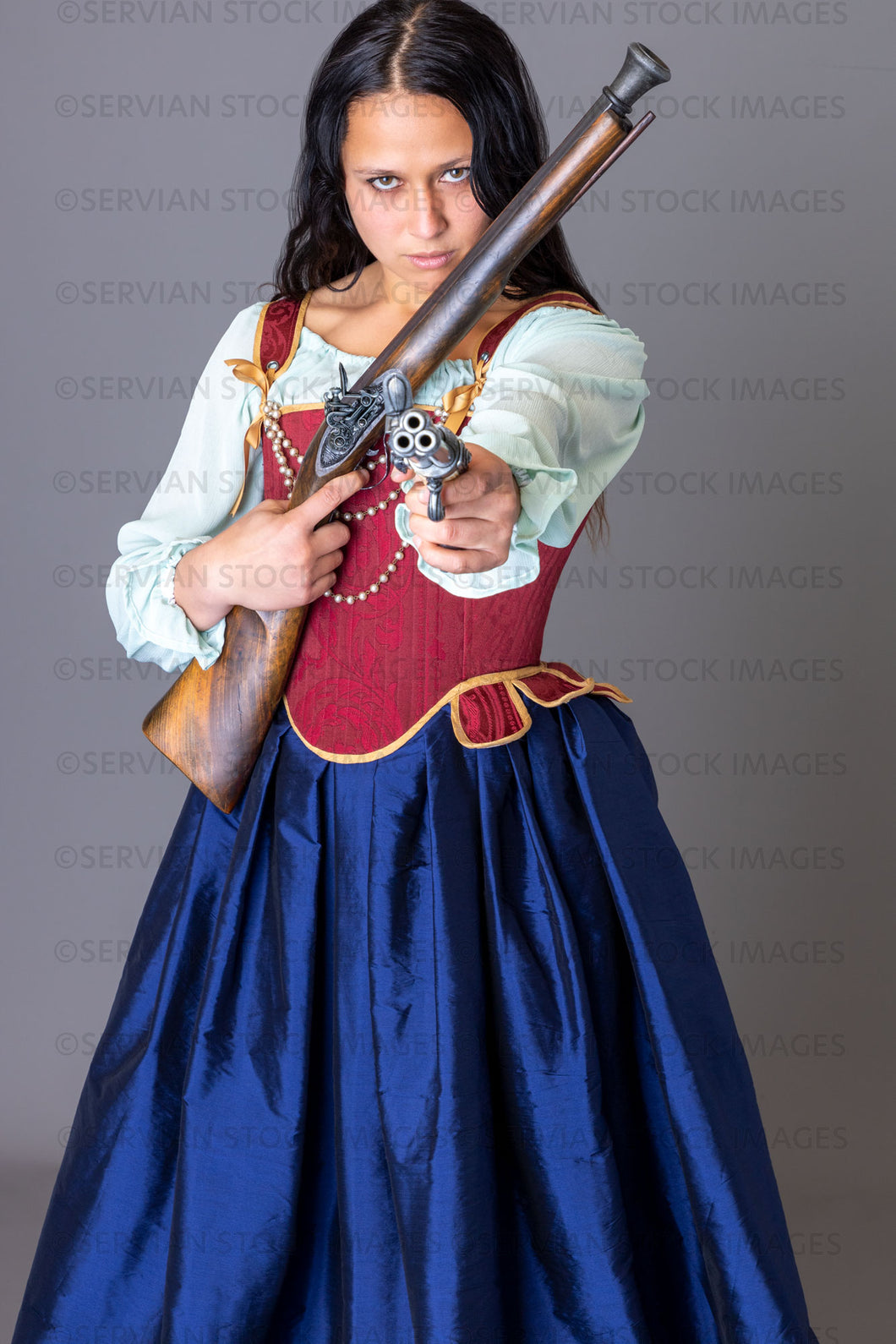 Pirate woman holding weapons against a grey backdrop (Sylvia 6032)