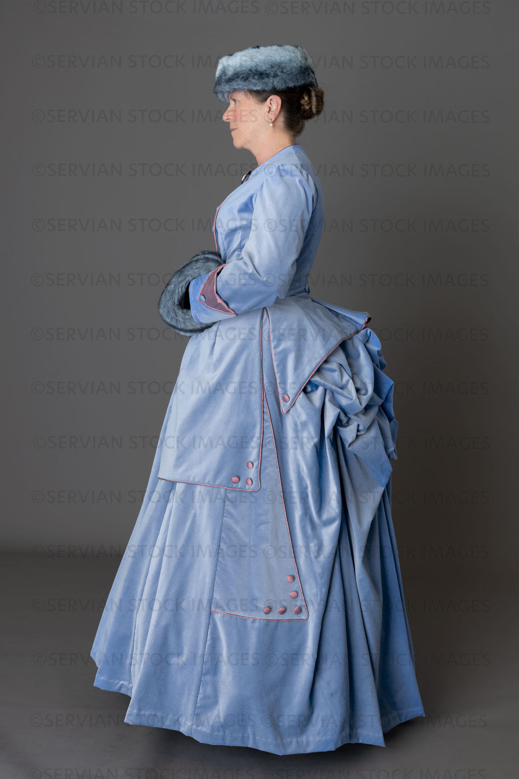Victorian woman in a pale blue winter ensemble with fur muff and hat (Tracey 6221)