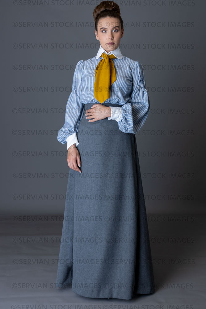 Edwardian woman wearing a striped cotton blouse with a mustard yellow cravat, and a grey walking skirt   (Sarah 8885)