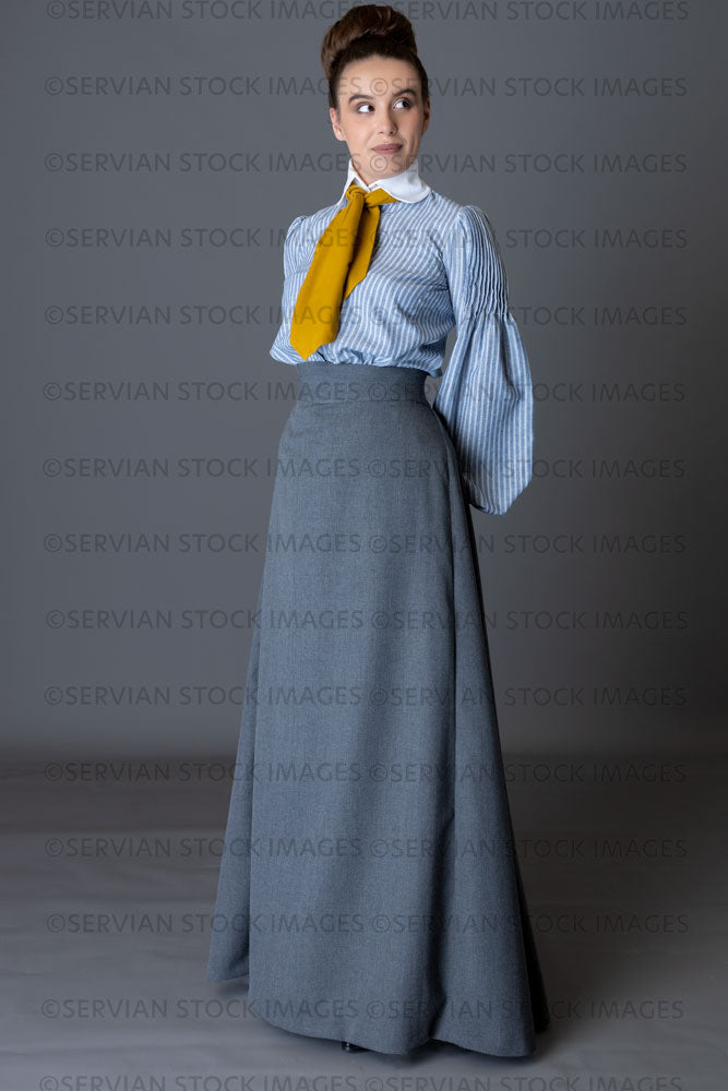 Edwardian woman wearing a striped cotton blouse with a mustard yellow cravat, and a grey walking skirt   (Sarah 8893)