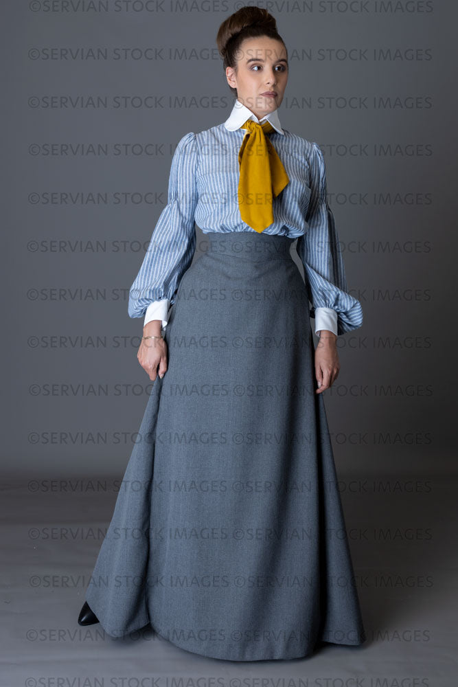 Edwardian woman wearing a striped cotton blouse with a mustard yellow cravat, and a grey walking skirt   (Sarah 8906)