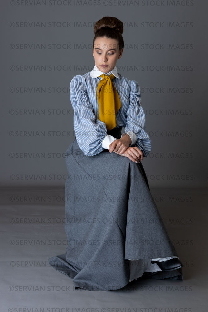 Edwardian woman wearing a striped cotton blouse with a mustard yellow cravat, and a grey walking skirt   (Sarah 8945)