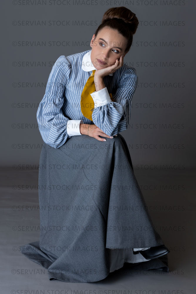 Edwardian woman wearing a striped cotton blouse with a mustard yellow cravat, and a grey walking skirt   (Sarah 8949)