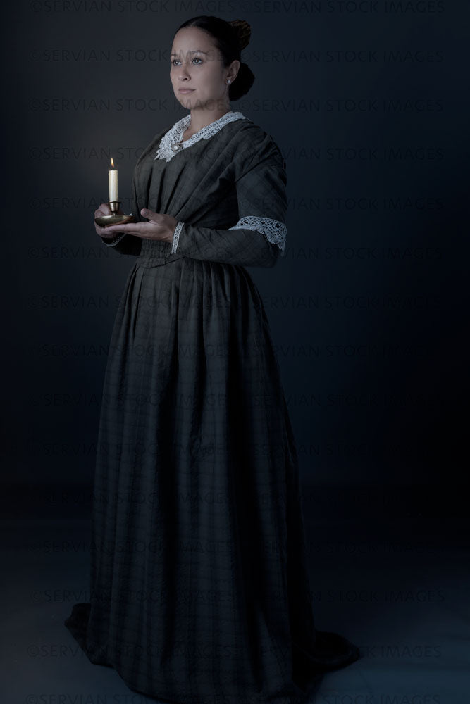 Working class Victorian woman holding a candle against a grey backdrop (Sylvia 1495)