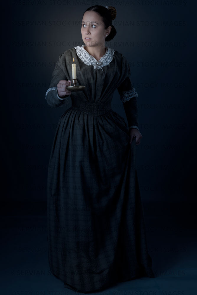 Working class Victorian woman holding a candle against a grey backdrop (Sylvia 1502)